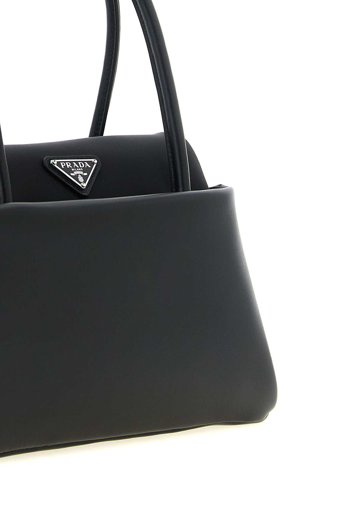 Detalle del logo triangular de metal esmaltado en el bolso Prada Passage